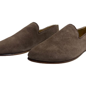 May include: A pair of brown suede loafers with a pointed toe.