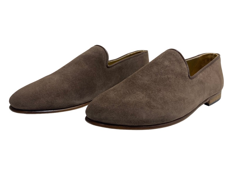 May include: A pair of brown suede loafers with a pointed toe.