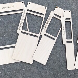 May include: Five light-colored wooden macrame boards of varying widths, each featuring cut-out slots and holes. A wooden ruler is placed on the left, showing measurements up to 11 inches. The boards are labeled with text including project board, alternating square knot, double half hitch, half knot, and square knot.