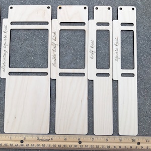 May include: Four light-colored wooden macrame knotting boards with cutouts and engraved text labels including alternating square knot, double half hitch, half knot, and square knot, positioned above a ruler measuring up to 11 inches.