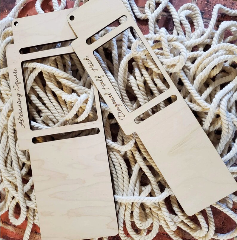 May include: Two light-colored wooden macrame knotting tools with rectangular cutouts. One tool is engraved with the text Alternating Square and the other with Diagonal Half Hitch. Both tools feature small circular holes at the top edge.