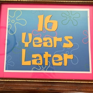 May include: A framed picture with a blue background and yellow text that reads "16 Years Later". The background has a pattern of green and blue starfish.