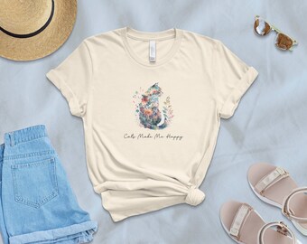 May include: A cream colored t-shirt with a watercolor design of a cat with flowers and the text "Cats Make Me Happy".
