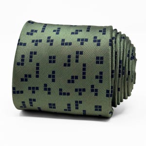 Puede incluir: Una corbata de seda verde con un patrón de Tetris azul marino.