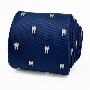 May include: A navy blue silk tie with a white tooth pattern. The tie is rolled up and ready to be worn.