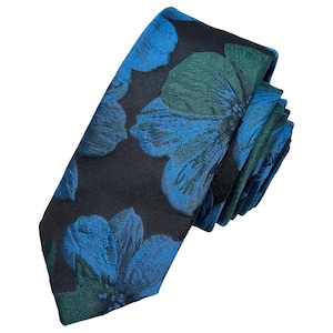 Peut inclure: Une cravate présentant un fond noir avec un motif floral tissé dans des tons de bleu vif et de vert forêt profond. Le tissu a un aspect texturé avec de grands pétales superposés qui créent un motif botanique audacieux et répétitif.