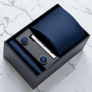Peut inclure: Ensemble de trois mugs en céramique crème, avec un glaçage moucheté. Chaque mug présente un motif floral peint à la main en bleu, vert et jaune. Les tasses ont une forme arrondie et une anse.