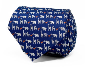 May include: A rolled necktie in a deep navy blue color featuring a repeating pattern of small white elephants, white giraffes, and tiny orange flamingos. The fabric has a visible diagonal ribbed texture throughout the entire surface of the tie.