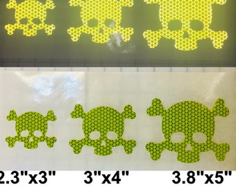 May include: Three yellow reflective skull and crossbones stickers in different sizes. The stickers are 2.3 inches by 3 inches, 3 inches by 4 inches, and 3.8 inches by 5 inches. The stickers are made of a reflective material that is designed to be visible in low-light conditions.
