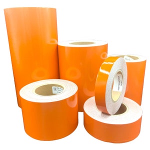 Könnte beinhalten: Vier Rollen orangefarbenes reflektierendes Klebeband. Die Rollen haben unterschiedliche Größen. Das Klebeband dient der Sicherheit und Sichtbarkeit.