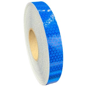Könnte beinhalten: Eine Rolle blaues reflektierendes Klebeband mit einem Rautenmuster. Das Klebeband befindet sich auf einem Pappkern.