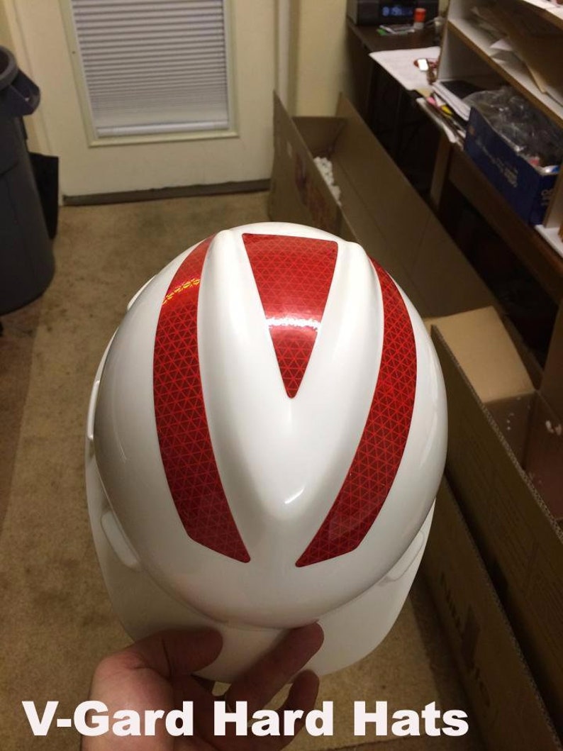 May include: White hard hat with red reflective strips. V-Gard Hard Hats.