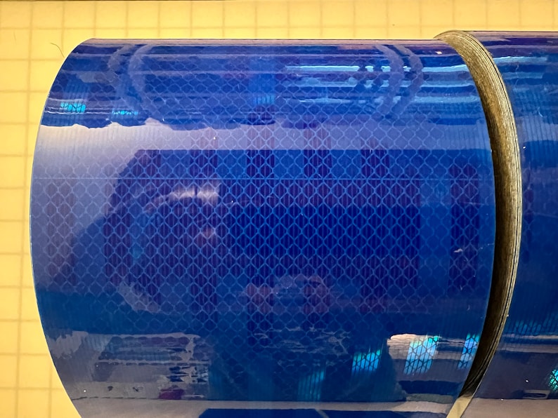 Puede incluir: Un rollo de cinta reflectante azul con un patr&oacute;n de diamante. La cinta est&aacute; enrollada y lista para ser utilizada.