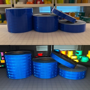 Puede incluir: Rollos de cinta reflectante azul, algunos est&aacute;n apilados uno encima del otro. La cinta tiene un patr&oacute;n de diamante.