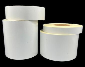 May include: Two rolls of white reflective tape. The larger roll is in the foreground and the smaller roll is behind it.