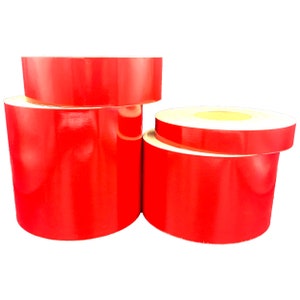 May include: Three rolls of red reflective tape. The rolls are different sizes.