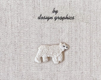 Può includere: Una copertina di diario in tessuto beige con il testo "MON JOURNAL D'ALBUM" e "by design graphics" in nero. Un piccolo orso polare ricamato bianco è centrato sotto il testo.