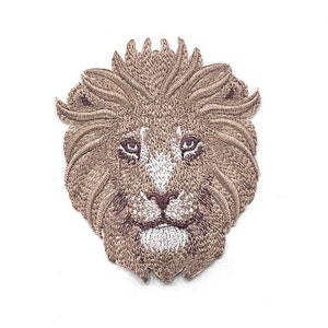 May include: Embroidered lion's head patch. The design uses brown and tan threads to depict the lion's mane and face, with white detailing on the muzzle and around the eyes. Suitable for application on clothing or accessories.