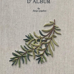 Könnte beinhalten: Ein beiges Notizbuch mit dem französischen Text "MON JOURNAL D'ALBUM" und "by design graphics" in Grau gedruckt. Ein gestickter Zweig aus grünen und braunen Blättern ziert die untere rechte Ecke des Einbands.