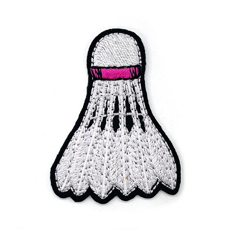 Peut inclure: &Eacute;cusson brod&eacute; d'un volant de badminton blanc avec une bande rose et un contour noir. Le volant pr&eacute;sente des coutures d&eacute;taill&eacute;es et un design classique, id&eacute;al pour les amateurs de sport ou les projets d'artisanat.