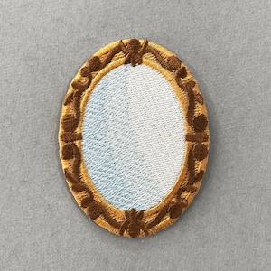 May include: Embroidered patch in the shape of an oval mirror. The mirror has a light blue center and a brown and gold decorative frame. The patch is likely for clothing or accessories.