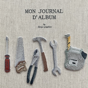 Op de afbeelding: Geborduurde gereedschappen, waaronder een schroevendraaier, zaag, tang, hamer, moersleutel en rolmaat, zijn gerangschikt op een beige stof. De tekst "MON JOURNAL D'ALBUM" en "by design graphics" staan bovenaan. De gereedschappen zijn grijs, bruin en rood.