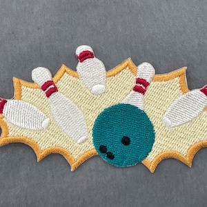 Pode incluir: Patch bordado com uma cena de boliche. O design inclui pinos brancos com listras vermelhas, uma bola de boliche turquesa e um fundo amarelo em forma de explosão. Para roupas ou acessórios.