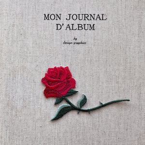 Könnte beinhalten: Ein beiger Stoff-Journal-Einband mit dem Text "MON JOURNAL D'ALBUM" und "by design graphics" in Schwarz. Eine rote gestickte Rose mit grünen Blättern und Stiel befindet sich auf dem Einband.