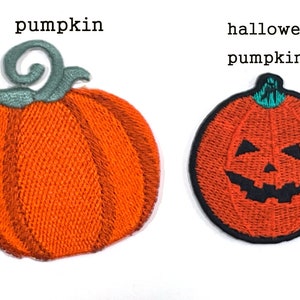 Peut inclure: Deux écussons brodés : une citrouille orange avec une tige verte et une citrouille d'Halloween avec un visage sculpté. Les mots "pumpkin" et "halloween pumpkin" sont au-dessus.