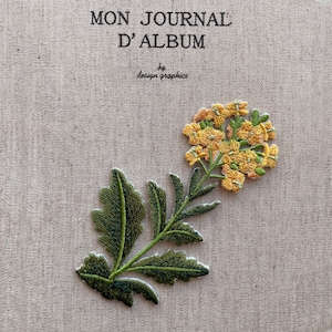 Puede incluir: Parche floral bordado con flores amarillas y hojas verdes sobre tela beige. El texto dice "MON JOURNAL D'ALBUM" y "by design graphics". Ideal para personalizar ropa o accesorios.