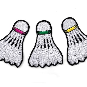 Peut inclure: Trois &eacute;cussons de volant brod&eacute;s avec des plumes blanches et des contours noirs. Chaque volant a une bande de couleur diff&eacute;rente : rose, vert et jaune. Parfaits pour d&eacute;corer des v&ecirc;tements ou des accessoires.