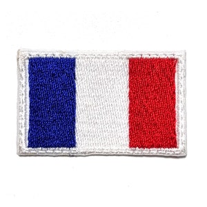 Puede incluir: Parche bordado con el diseño de la bandera francesa. El parche rectangular tiene rayas verticales en azul, blanco y rojo, con un borde blanco. Los colores son vibrantes y la costura es detallada, creando una apariencia texturizada.