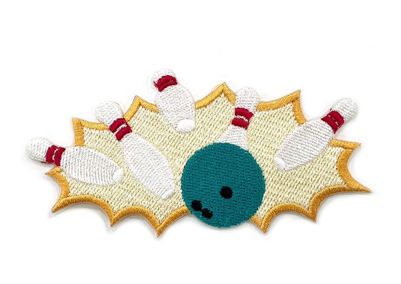 May include: Embroidered patch featuring a bowling scene. The design includes white bowling pins with red stripes, a teal bowling ball, and a yellow burst background. The patch is likely for clothing or accessories.