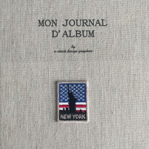 May include: A square embroidered patch featuring the Statue of Liberty, the American flag, and the text "NEW YORK." The patch is on a light beige fabric with the text "MON JOURNAL D'ALBUM" and "a-check design graphics."