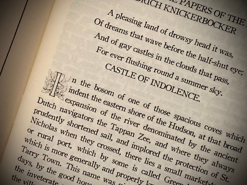 K&ouml;nnte beinhalten: Nahaufnahme einer Buchseite mit gedrucktem Text. Der Titel "The Papers of the Diedrich Knickerbocker" ist sichtbar. Der Text enth&auml;lt S&auml;tze wie "Castle of Indolence" und erw&auml;hnt den Hudson River und Tarry Town.