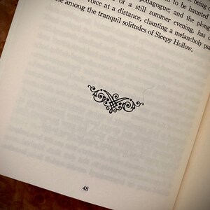 K&ouml;nnte beinhalten: Offene Buchseite mit gedrucktem Text und einer dekorativen schwarzen Verzierung. Die Seitenzahl 48 ist unten sichtbar. Der Text ist in schwarzer Schrift auf einer wei&szlig;en Seite.