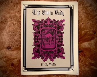 Könnte beinhalten: Der Einband eines Buches mit dem Titel "The Stolen Body" von H.G. Wells. Der Einband zeigt eine Schwarzweißillustration von zwei Figuren in einem Raum mit einem großen, verzierten Rahmen.