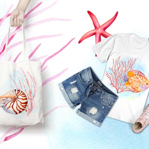 Pu&ograve; includere: Una borsa tote bianca con un'illustrazione ad acquerello di una conchiglia di nautilus e corallo. La borsa &egrave; tenuta da una mano.
