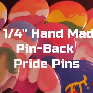 May include: A close-up of 2 1/4" hand-made pin-back pride pins. The pins are round and feature a variety of colorful designs with dripping paint effects.