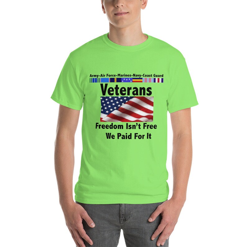 May include: A neon green t-shirt with the word "Veterans" above a waving American flag. The shirt also features the text "Freedom Isn't Free We Paid For It" and the names of the military branches.