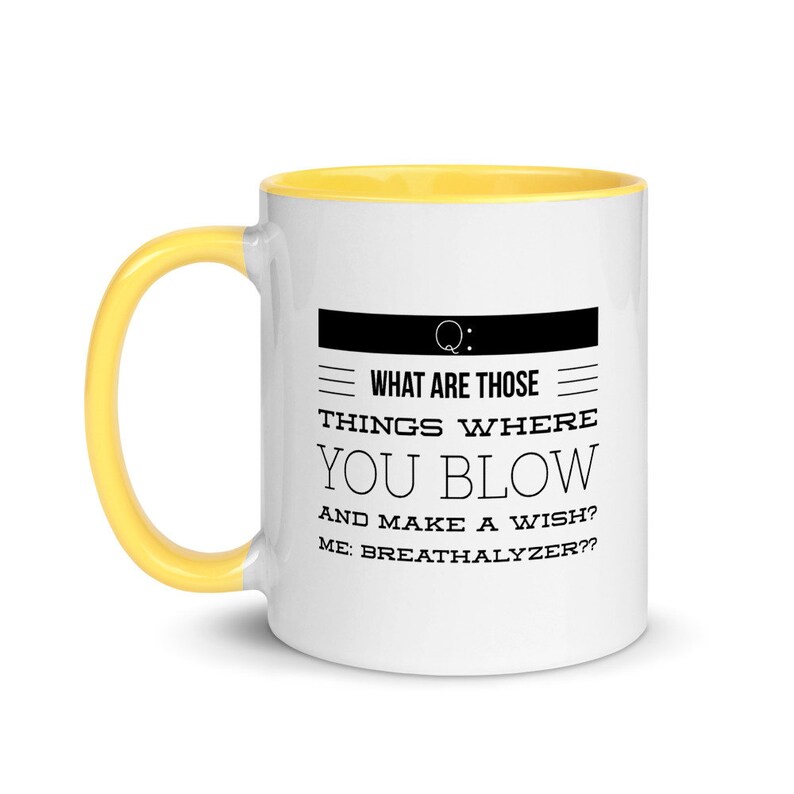 May include: White ceramic mug with a yellow handle and interior. The mug features the text "WHAT ARE THOSE THINGS WHERE YOU BLOW AND MAKE A WISH? ME: BREATHALYZER??" in black, with a black rectangle and a question mark.