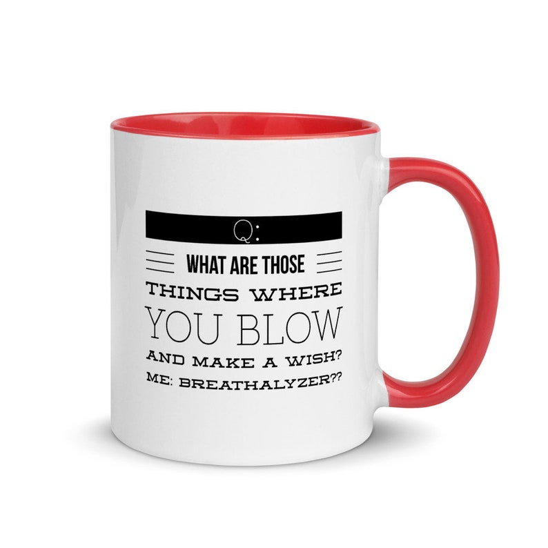 May include: White ceramic mug with a red interior and handle. The mug features the text "WHAT ARE THOSE THINGS WHERE YOU BLOW AND MAKE A WISH? ME: BREATHALYZER??" in black, with a question mark symbol.