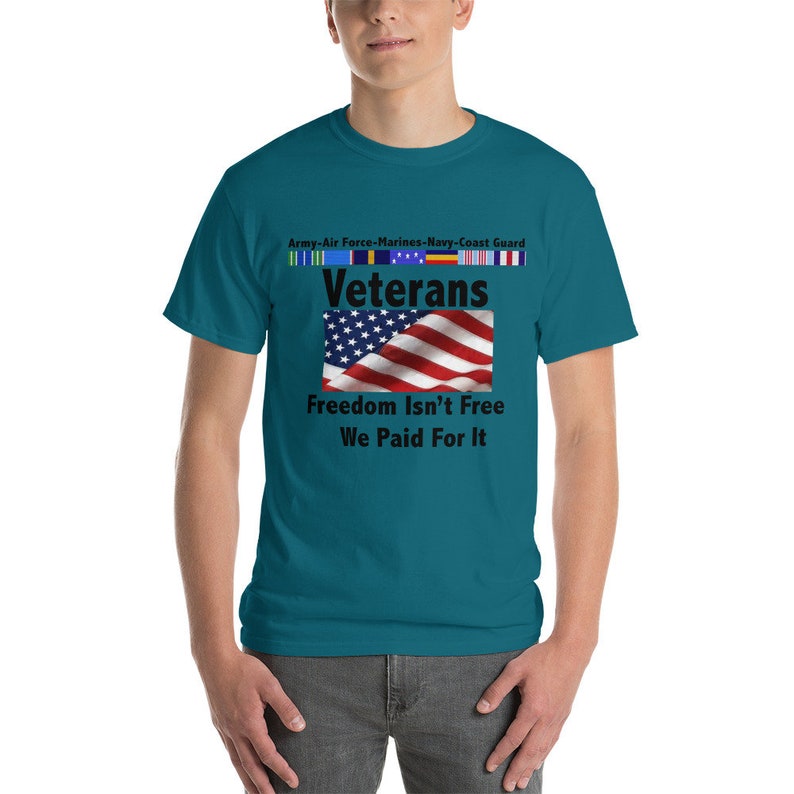 May include: Teal t-shirt with the text "Veterans" above a waving American flag. The shirt also features the text "Freedom Isn't Free, We Paid For It" and ribbons representing the Army, Air Force, Marines, Navy, and Coast Guard.