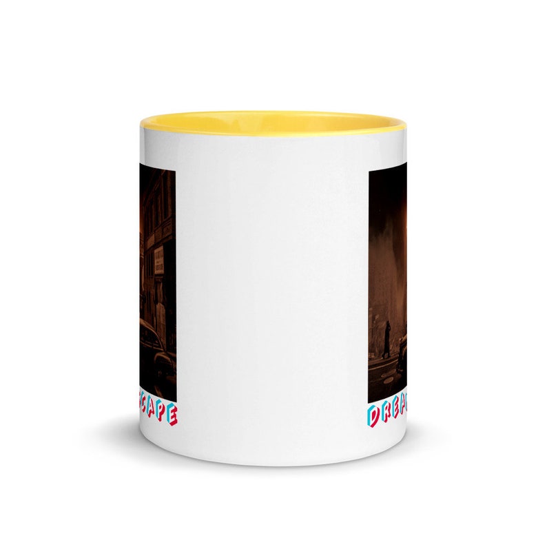 May include: White ceramic coffee mug with a yellow interior. The mug features a wraparound design of a city scene in sepia tones. The word "DREAMSCAPE" is printed in a colorful, stylized font near the bottom of the mug.