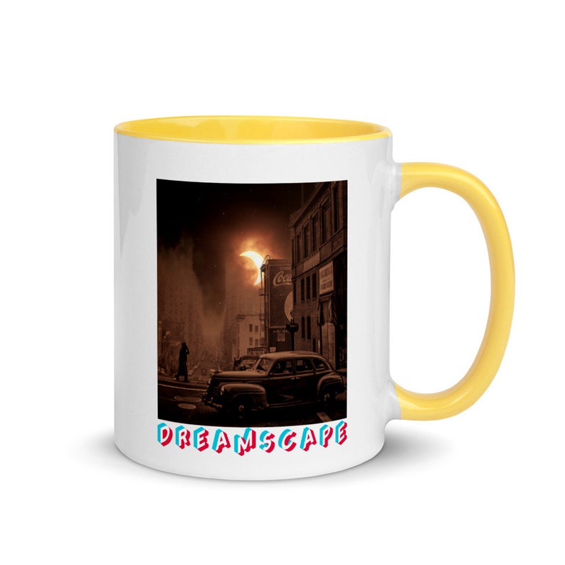 May include: White ceramic mug with a yellow interior and handle. The mug features a sepia-toned image of a vintage car on a city street with the word "DREAMSCAPE" in colorful text. A unique coffee mug.