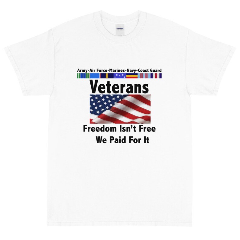 May include: White t-shirt with the text "Veterans" above an American flag graphic. Below the flag, the shirt reads "Freedom Isn't Free, We Paid For It." Above the word "Veterans" are service ribbons and the text "Army-Air Force-Marines-Navy-Coast Guard."