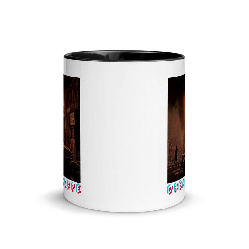 May include: White ceramic coffee mug with a black interior and a wraparound illustration. The illustration depicts a street scene with buildings and a car. The word "DREAMSCAPE" is printed in red and blue on the mug.