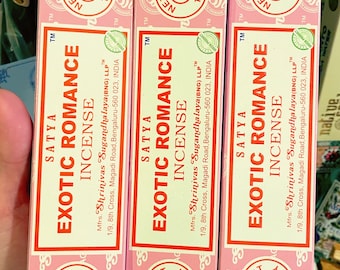 May include: Three pink boxes of Satya Exotic Romance incense. Each box has a white label with the brand name, product name, and manufacturer information. The boxes are stacked on top of each other.