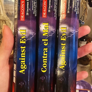 May include: Three boxes of incense sticks with a red and black design. The boxes are labeled "Against Evil", "Contra el Mal", and "Against Evil". The boxes also feature the text "Dragon's Blood" and "20 Incense Sticks".