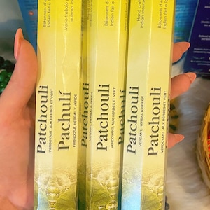 May include: Three boxes of Patchouli incense sticks. The boxes are yellow with green and white text and imagery. The text includes the words "VERDOYANT, AUX HERBES ET VERT" and "Hand crafted Indian incense sticks."